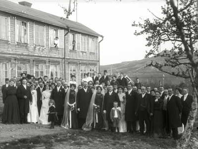 Dubbelbrölop, brudpar och gäster utanför "milijonpelles" hus