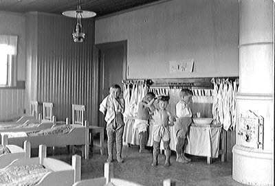 Barn i sovsal står och tvättar sig.