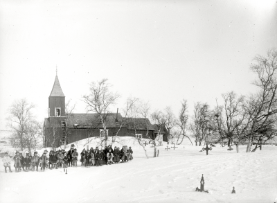 Kyrka och kyrkogård med samer i förgrunden.