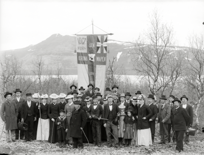 Medlemmar i Nykterhetslogen Kiruna Wapen samlade till fest på Haukivaara år 1902. Som nr två till höger om standaret står ¨handlare¨ Norrbom.