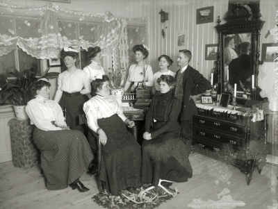 Interiörbild av grupp i hemmiljö år 1915.