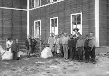 Barngrupp utanför arbetsstugan i Jokkmokk den 5 september 1913. Fru Svedelius i hatt.