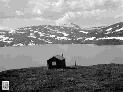 En stuga (renvaktarstuga) vid en sjö i fjällvärlden