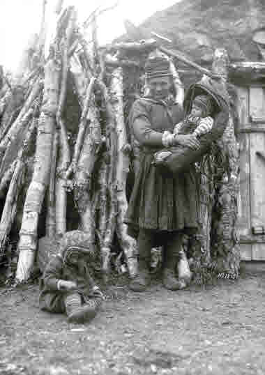 Maria Sarri stående vid kåtan med de minsta barnen den 22 augusti 1915.